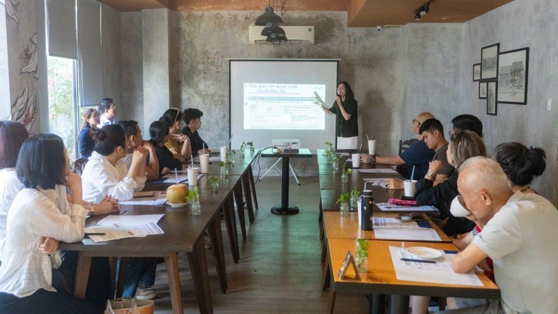 A presenter leading a seminar with participants seated around a table